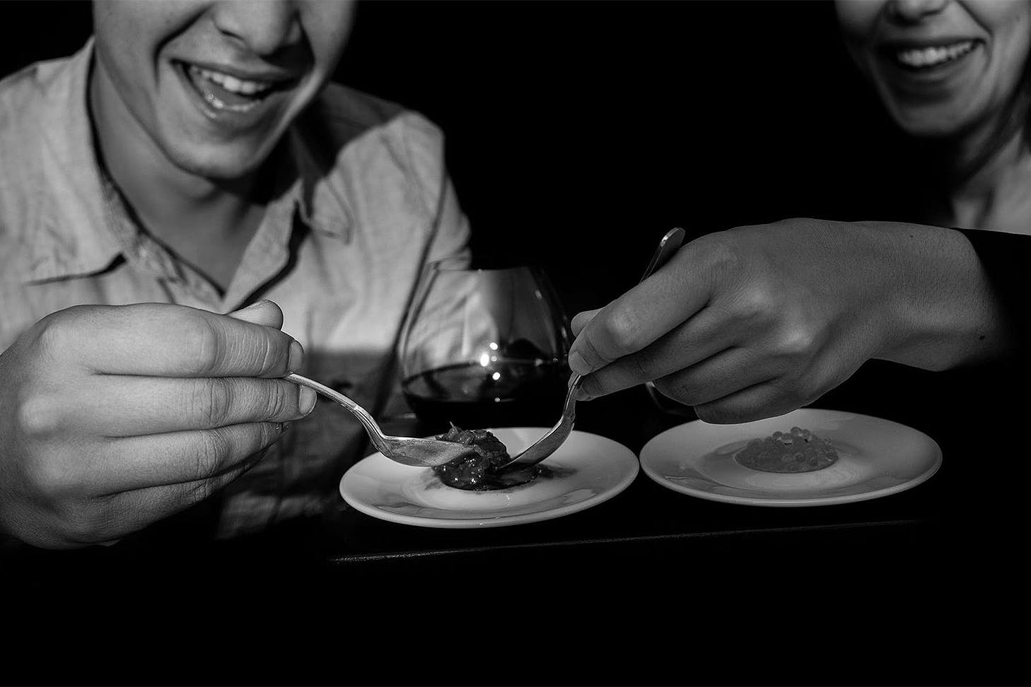 Two people enjoy a dish in the dark.